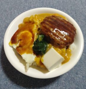 どんぶりご飯に、豆腐、ホウレンソウ、卵焼き、レトルトカレー、そして最後にハンバーグのせ！